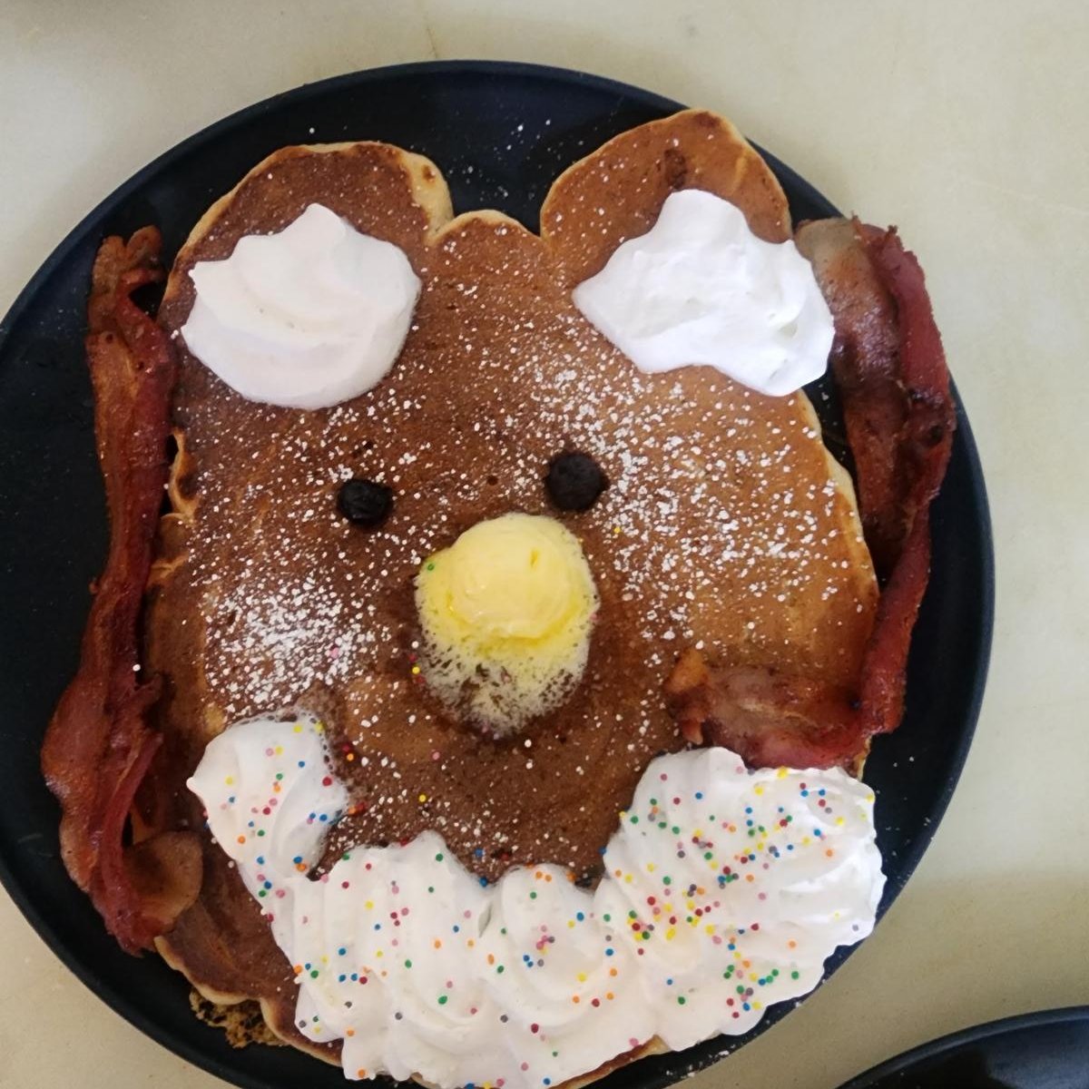 The bearcub pancake from the kids' menu — a bear face with whipped cream ears