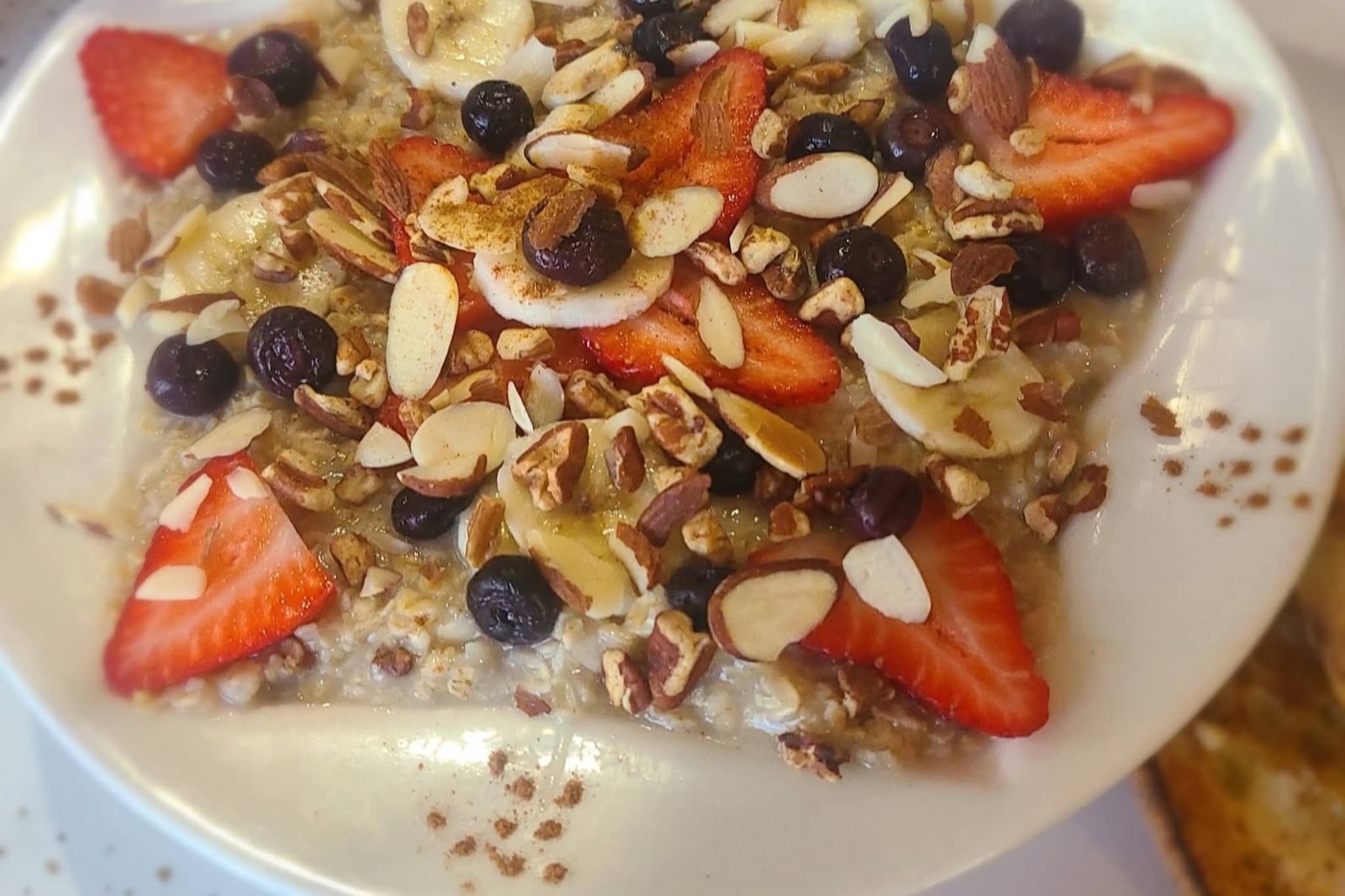 Mama Bears porridge — Irish oatmeal piled with strawberries, blueberries, banana, almonds and caramelized pecans