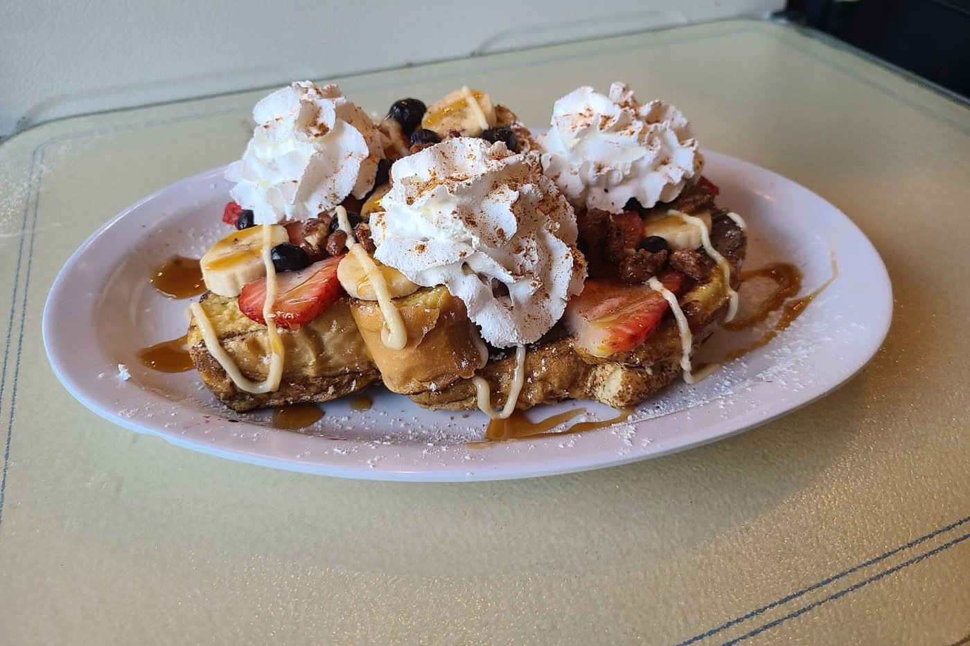 The Snow Capped French toast, piled with fruit, pecans and whipped cream caps